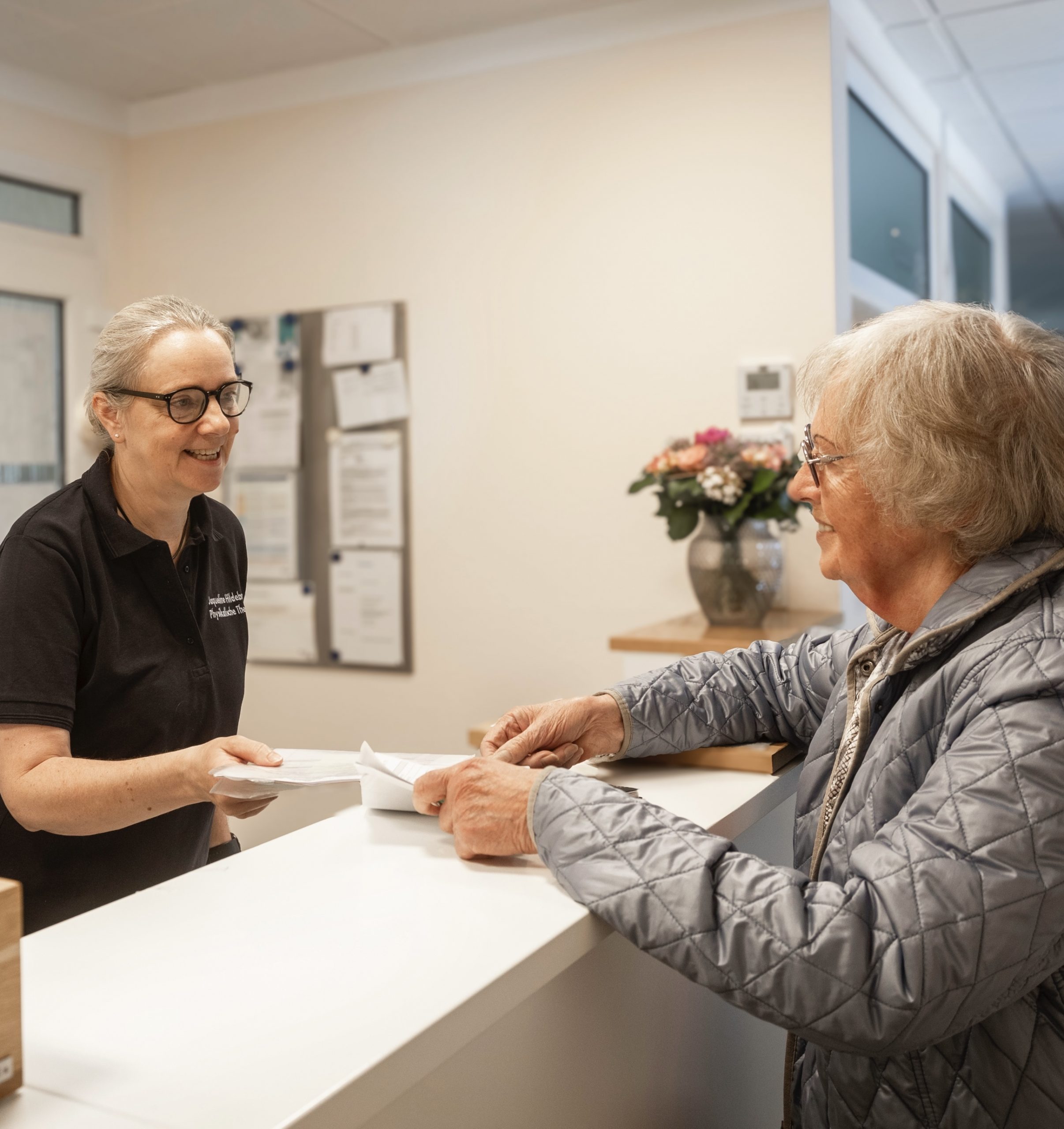 Ein Patient steht an der Anmeldung in der Praxis